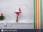 a-human-hand-sticking-out-of-a-bathtub-holding-a-toy-boat-X8H1WA.jpg