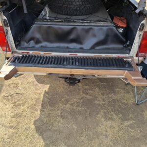 Bed setup with hidden storage drawers beneath spare tire.