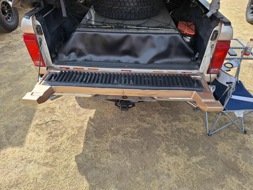 Bed setup with hidden storage drawers beneath spare tire.