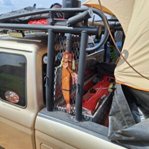 Detail of roof rack setup with LED light bar, traction boards, and PVC water tank.