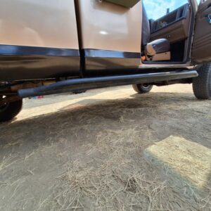 Close-up of rock sliders salvaged from a Chevy Silverado protecting the rocker panels.