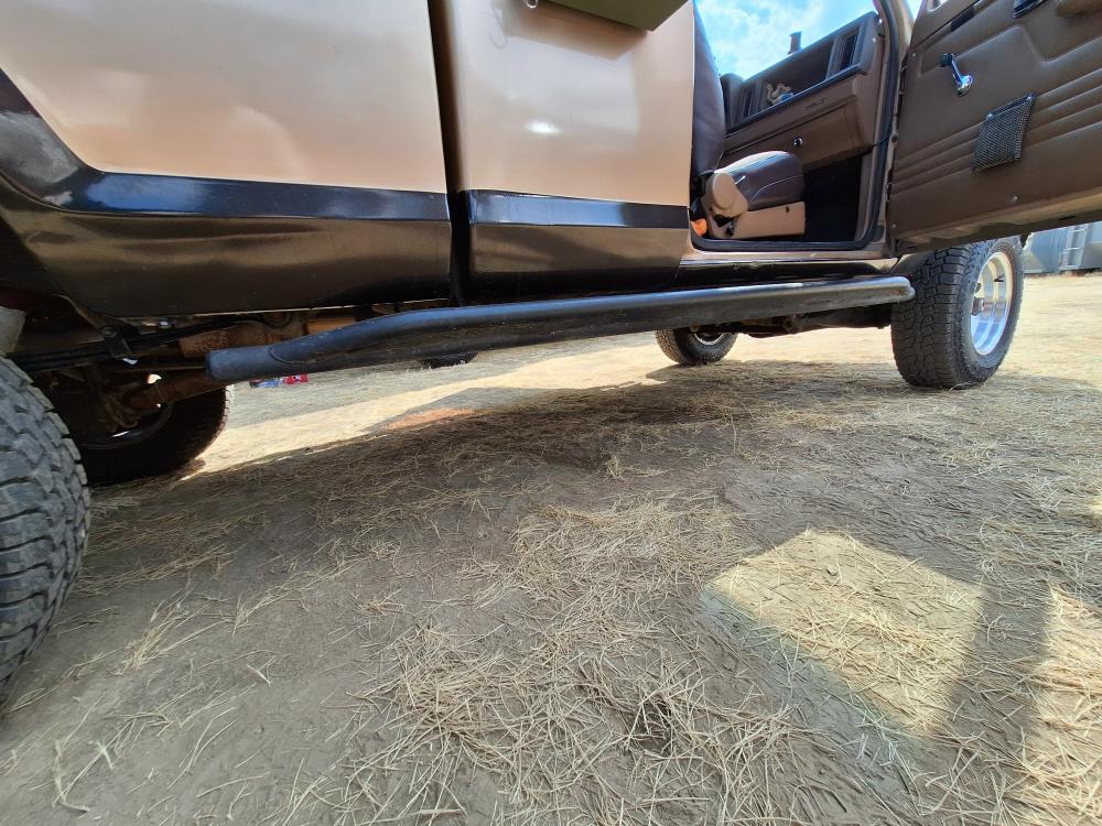 Close-up of rock sliders salvaged from a Chevy Silverado protecting the rocker panels.