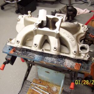 Top view of pilot holes. It looks kind of funny because the cast-in bosses that are on this intake are not exactly made on the same centers that the CHP fuel rail is. This pic was taken after the holes had been enlarged to 1/2".  The bungs I'm using require a 7/8" hole.
