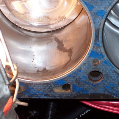 Then it happened....  After running for a while, I noticed water dripping from the #4 header tube.  I finally pull the head and discover  a crack in the cylinder wall and a nicked up piston and combustion chamber.