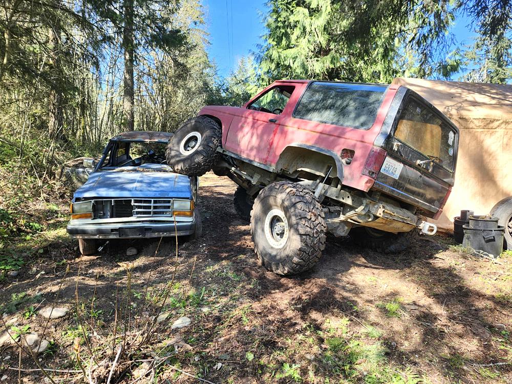 Hell Boy Ford Bronco II climbing over a Ford Ranger